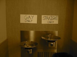 A bathroom with two sinks and a sign that says gay straight only.
