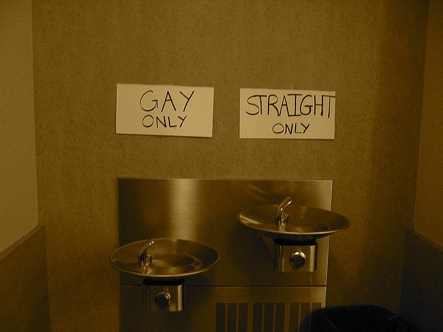 A bathroom with two sinks and a sign that says gay straight only.