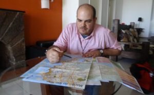 A man sitting at a table looking at a map.