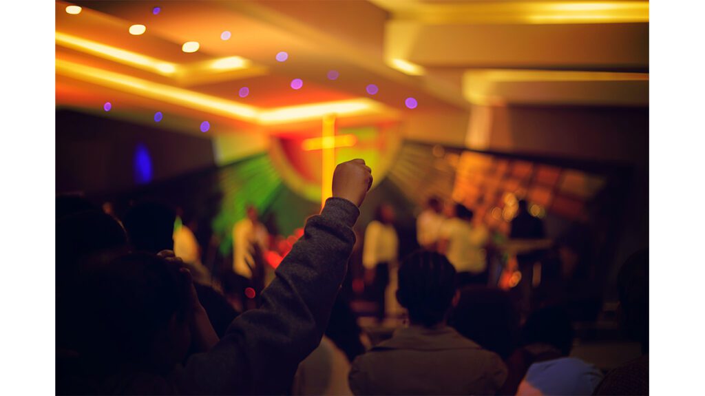 A group of people at a concert with their hands raised.