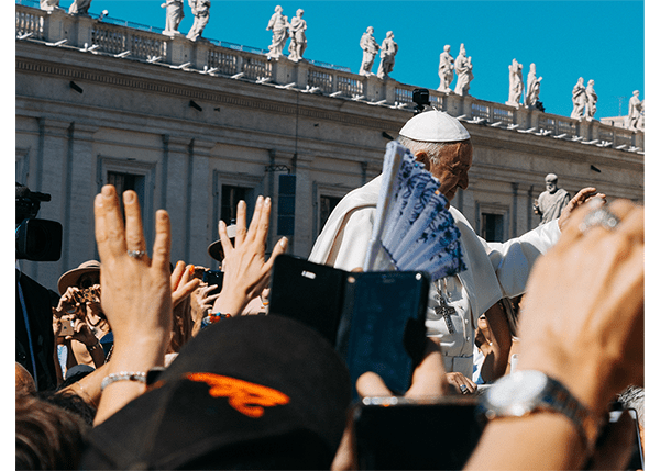 Pope john paul ii waves to a crowd of people.