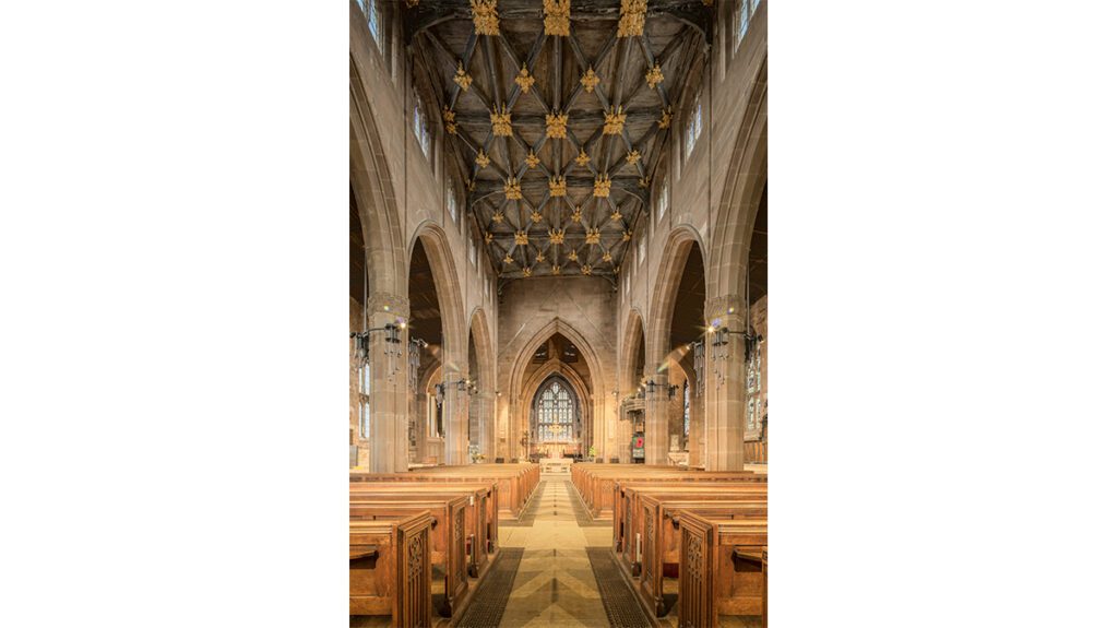 The inside of a church with wooden pews.