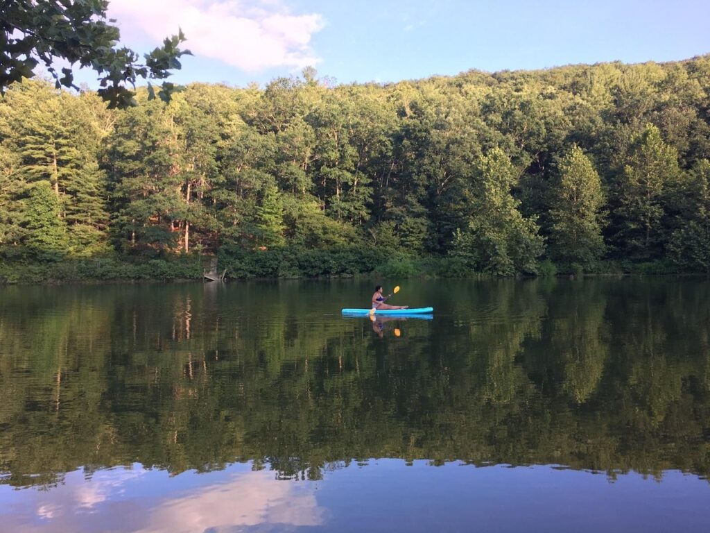 A person is paddling a kayak on a lake.