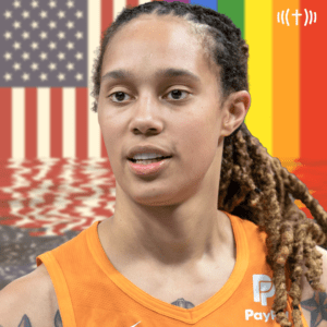 A basketball player with dreadlocks in front of an american flag.