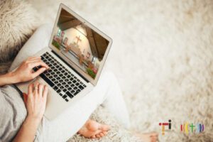 A woman using a laptop with a picture of a house on it.